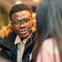 International Anchor Allies Winter 2026 First Mixer - portrait of a male student in a chat with another student